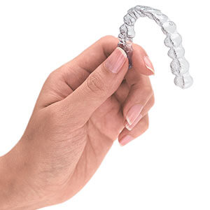 Image of hand hold an Invisalign Clear Aligner