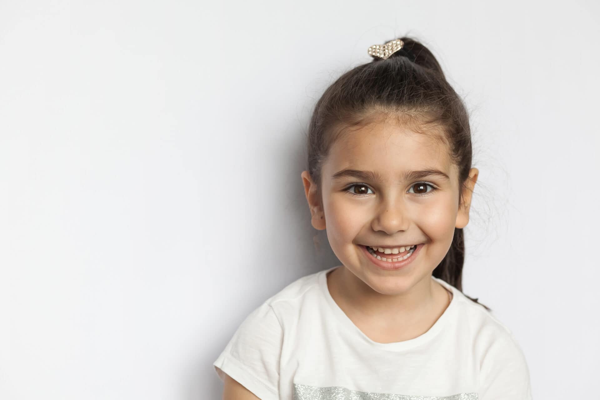 Portrait of happy cute brunette child  girl on white background